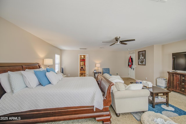 bedroom with carpet flooring, a closet, a ceiling fan, and a walk in closet
