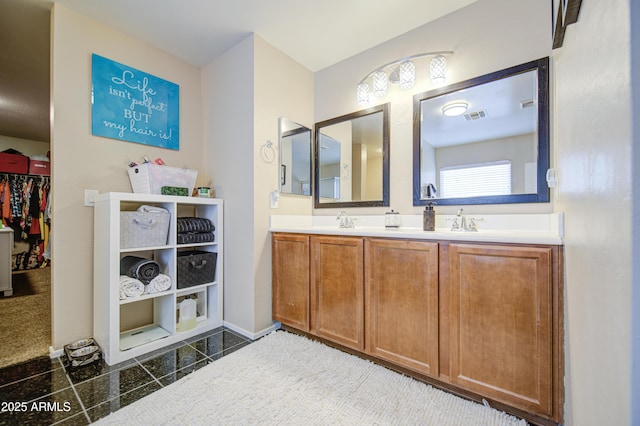 full bathroom with granite finish floor, double vanity, visible vents, and a sink