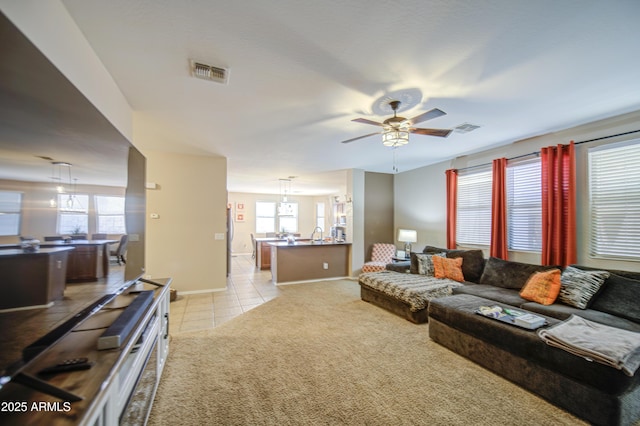 living area featuring a healthy amount of sunlight, light carpet, and visible vents