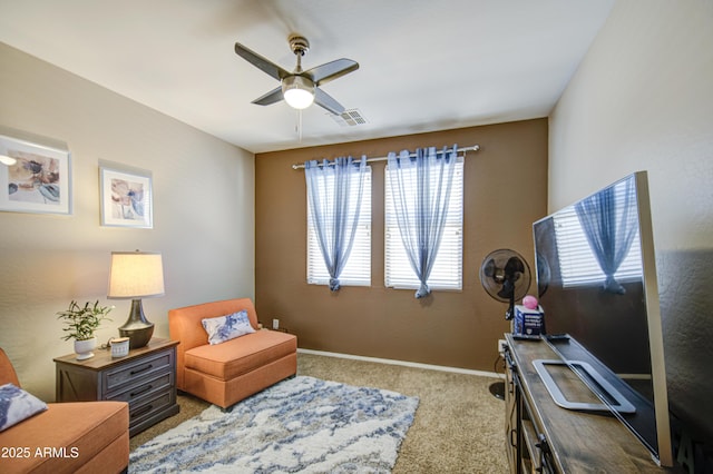 living area with carpet flooring, visible vents, baseboards, and ceiling fan