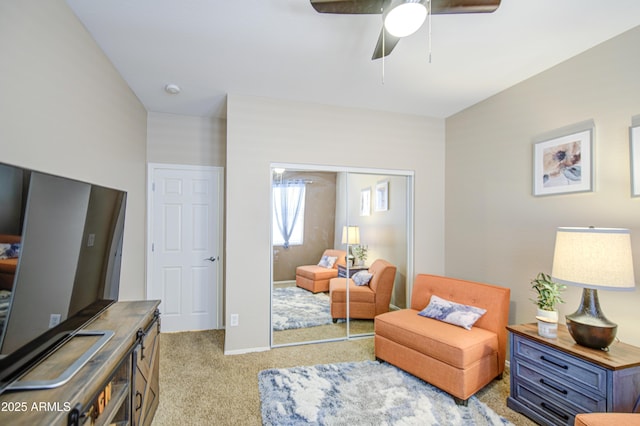 sitting room with baseboards, ceiling fan, and carpet