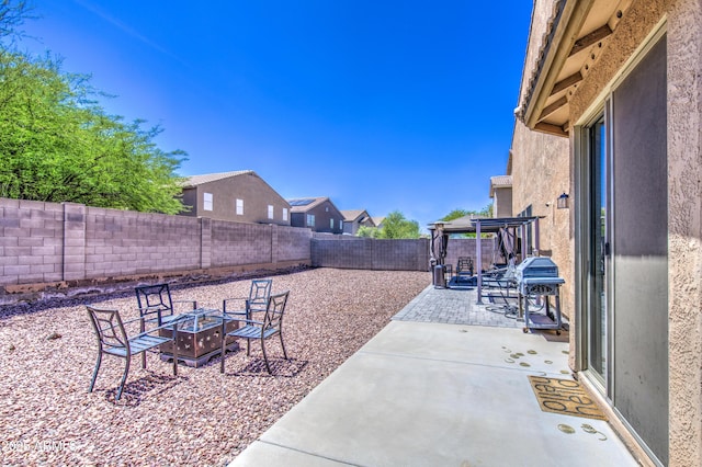 view of patio with a fire pit, a fenced backyard, and grilling area