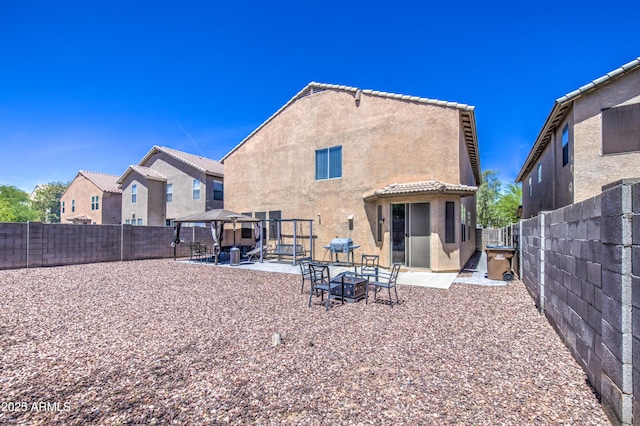 back of house with a gazebo, a patio area, stucco siding, and a fenced backyard