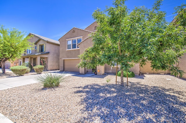 view of front of house featuring driveway, stucco siding, and a garage
