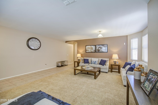 living room featuring visible vents, baseboards, and arched walkways