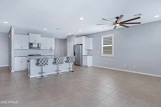 4628 W Greenleaf Dr, San Tan Valley, AZ 85144 - kitchen with appliances with stainless steel finishes, decorative backsplash, ceiling fan, recessed lighting, and white cabinetry