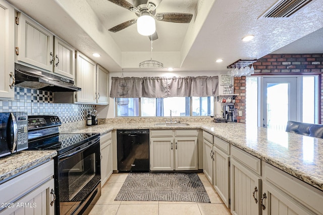 kitchen with sink, black appliances, kitchen peninsula, light stone countertops, and decorative backsplash