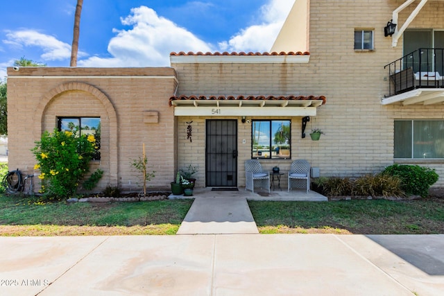 541 N Lesueur St, Mesa, AZ 85203 - view of front of home featuring a tile roof, a balcony, and brick siding