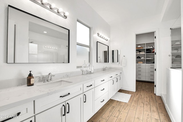 bathroom with wood-type flooring, vanity, and walk in shower