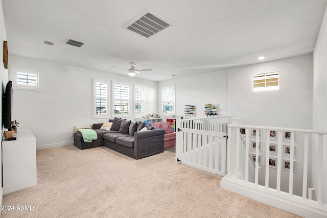 living room featuring light carpet, ceiling fan, and plenty of natural light