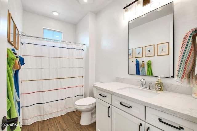 bathroom with curtained shower, toilet, vanity, and hardwood / wood-style floors