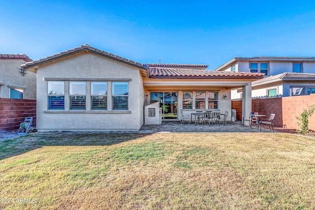 back of house featuring a patio and a yard