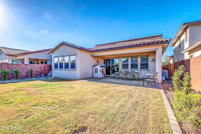 rear view of property featuring a patio and a yard