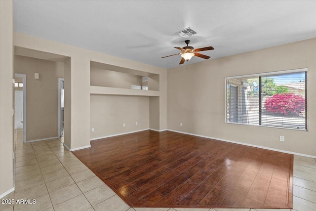 21192 E Stirrup St, Queen Creek, AZ 85142 - unfurnished living room featuring light tile patterned floors, visible vents, ceiling fan, and baseboards