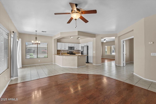 21192 E Stirrup St, Queen Creek, AZ 85142 - unfurnished living room with light tile patterned flooring, visible vents, baseboards, and ceiling fan with notable chandelier