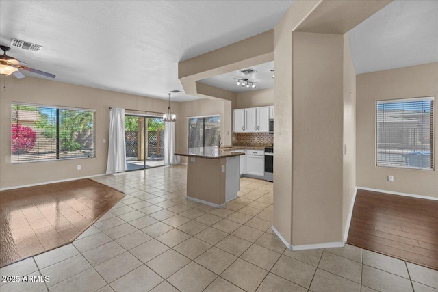 21192 E Stirrup St, Queen Creek, AZ 85142 - kitchen with light tile patterned floors, tasteful backsplash, visible vents, white cabinets, and open floor plan