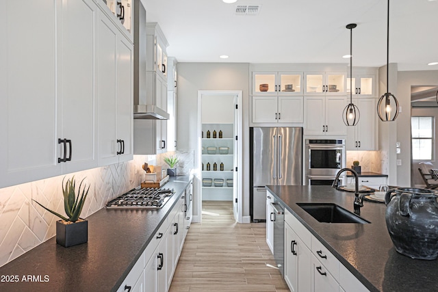 kitchen with pendant lighting, sink, white cabinetry, and stainless steel appliances