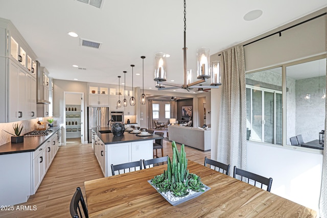 dining room with sink, an inviting chandelier, and light hardwood / wood-style flooring