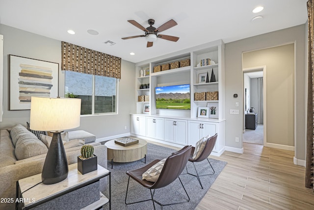 living room featuring ceiling fan, built in features, and light wood-type flooring