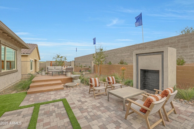 view of patio with a wooden deck and an outdoor living space with a fireplace