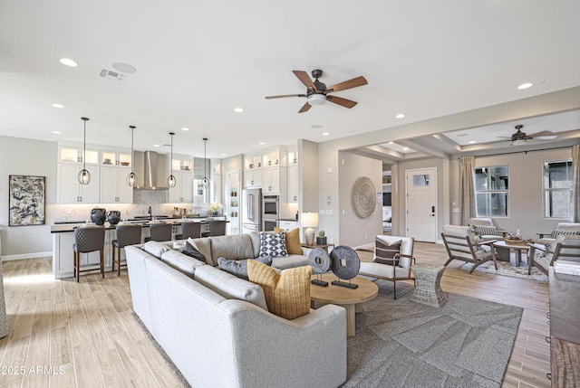 living room featuring ceiling fan and light hardwood / wood-style floors