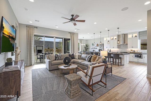 living room featuring ceiling fan and light wood-type flooring