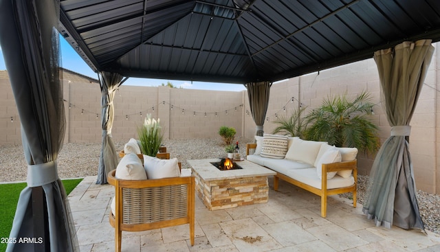 view of patio / terrace with an outdoor living space with a fire pit, a fenced backyard, and a gazebo