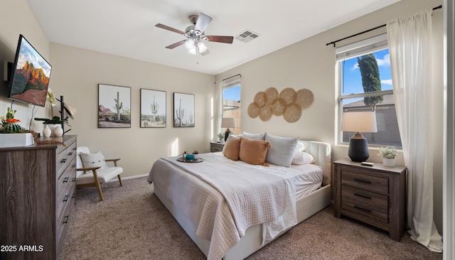 bedroom featuring light carpet, multiple windows, visible vents, and baseboards