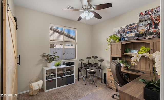 office area featuring carpet, a barn door, baseboards, and a ceiling fan