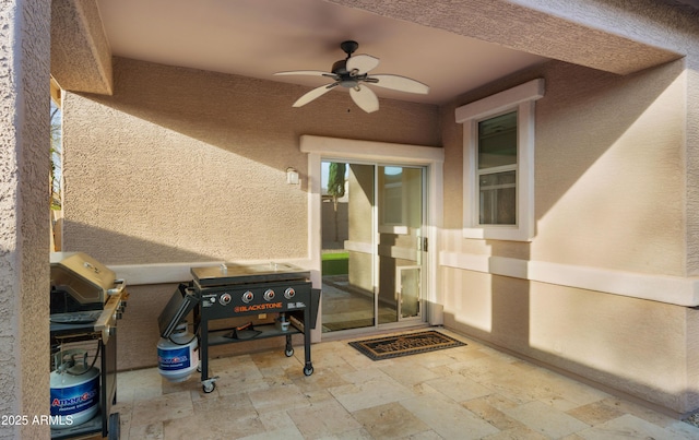 view of exterior entry featuring ceiling fan, a patio, and stucco siding