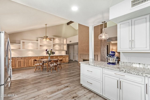 kitchen featuring light wood finished floors, stainless steel refrigerator with ice dispenser, decorative light fixtures, and white cabinets