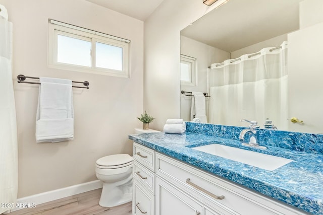 full bath featuring vanity, wood finished floors, toilet, and baseboards