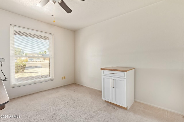 spare room with a ceiling fan and light carpet