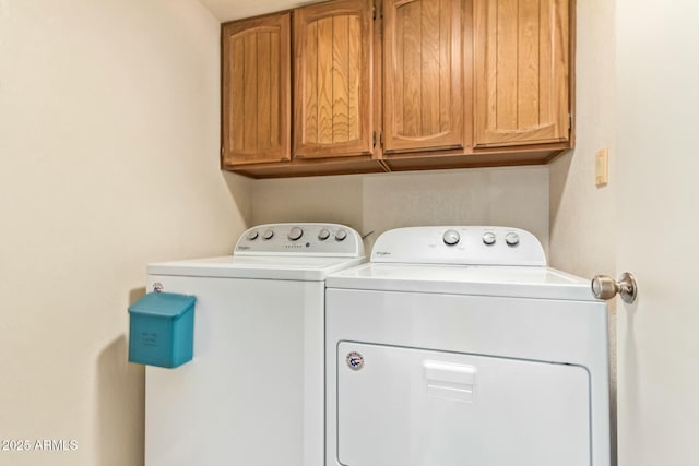 laundry room featuring washing machine and clothes dryer and cabinet space