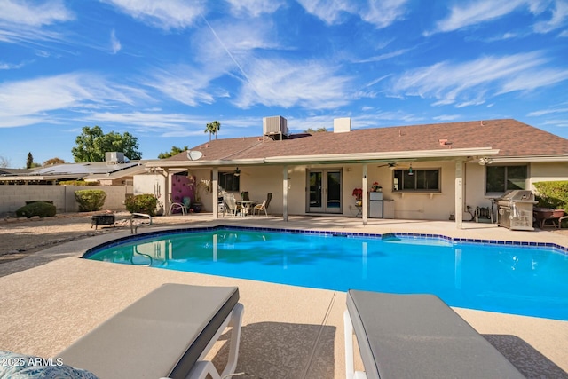 view of pool with central AC, a patio area, fence, and a ceiling fan