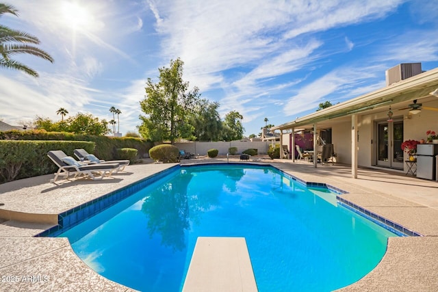 view of swimming pool featuring a fenced in pool, a patio area, ceiling fan, a fenced backyard, and a diving board