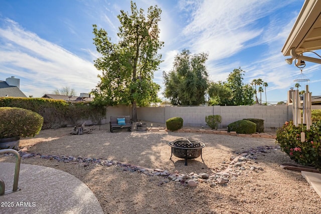 view of yard featuring a fenced backyard and a fire pit