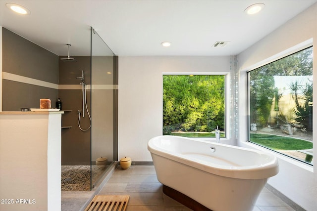 bathroom with shower with separate bathtub and tile patterned floors