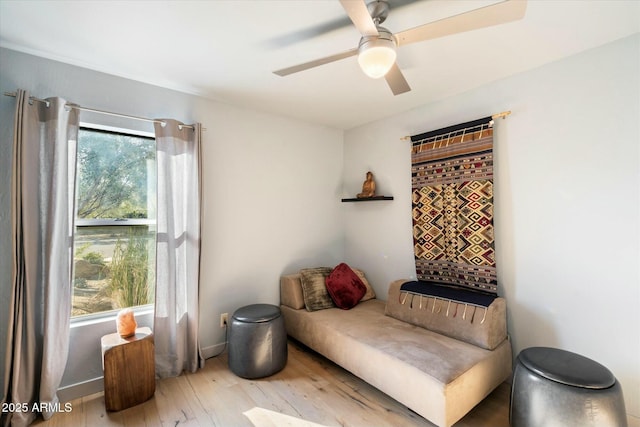 living area featuring ceiling fan and light hardwood / wood-style flooring