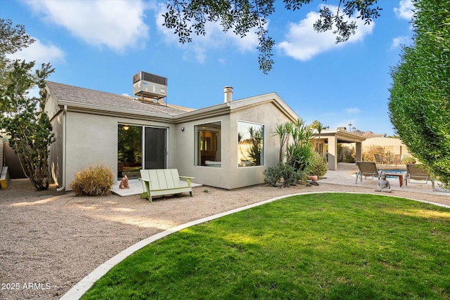 back of property with central AC unit, a lawn, and a patio