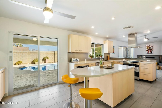 kitchen featuring island range hood, kitchen peninsula, a breakfast bar, and a center island