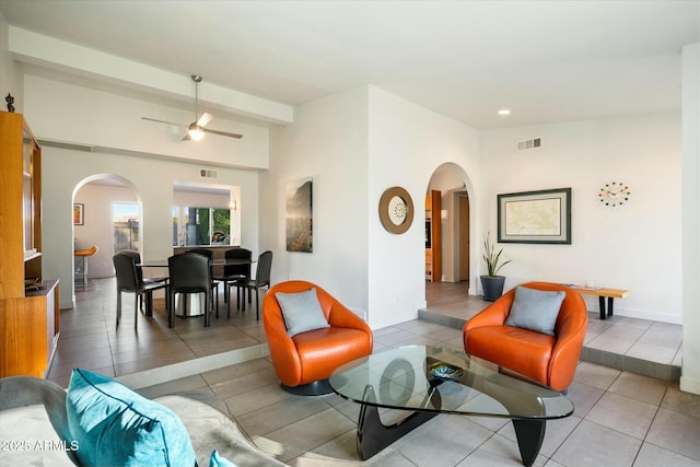 tiled living room featuring ceiling fan and beamed ceiling