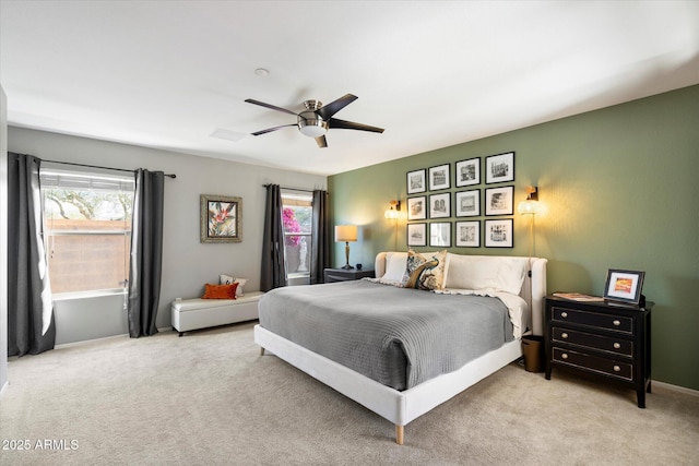 bedroom with light carpet, multiple windows, and ceiling fan