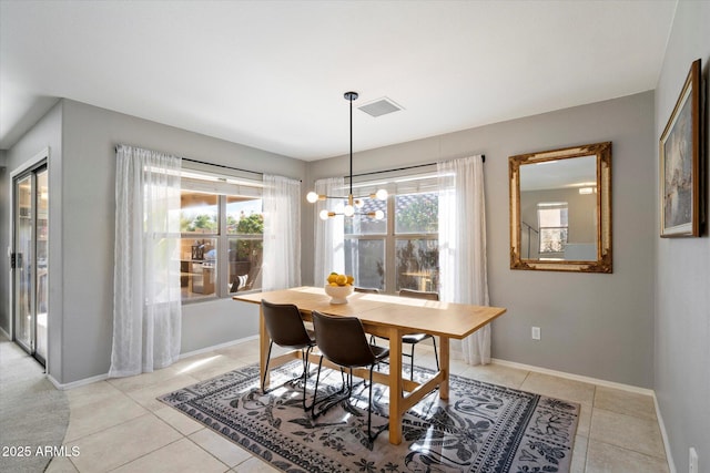 tiled dining space featuring plenty of natural light and a chandelier