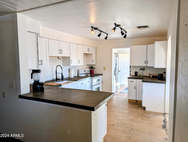 kitchen featuring double oven range, visible vents, a sink, stainless steel refrigerator with ice dispenser, and dark countertops