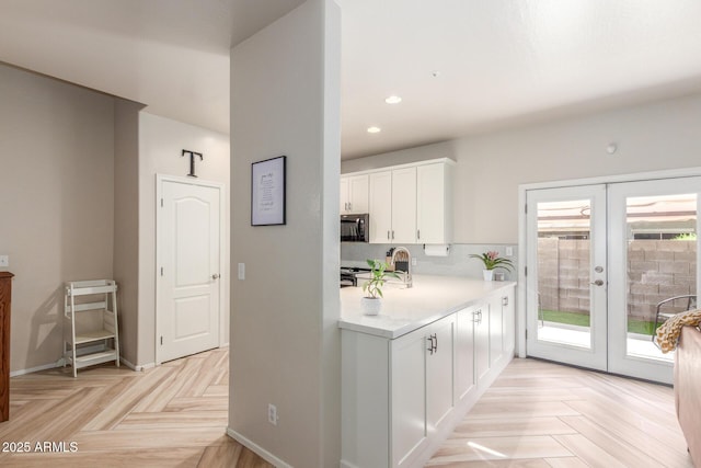 13540 N 87th Dr, Peoria, AZ 85381 - kitchen with black microwave, white cabinets, light countertops, french doors, and recessed lighting