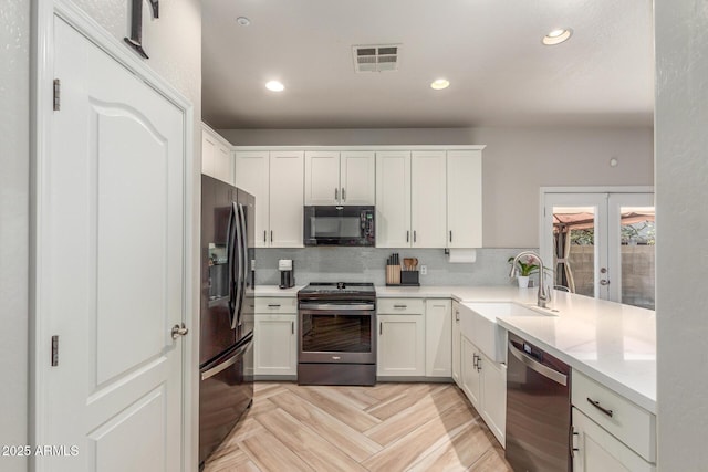 13540 N 87th Dr, Peoria, AZ 85381 - kitchen featuring stainless steel appliances, french doors, a sink, light countertops, and decorative backsplash