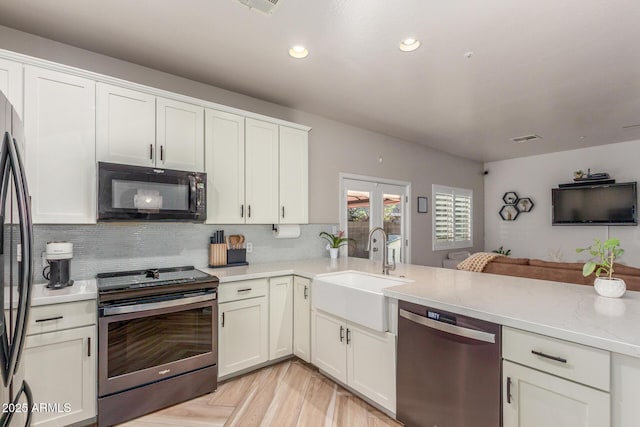 13540 N 87th Dr, Peoria, AZ 85381 - kitchen with appliances with stainless steel finishes, a sink, tasteful backsplash, white cabinetry, and a peninsula