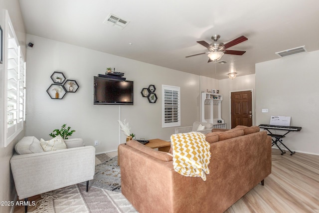 13540 N 87th Dr, Peoria, AZ 85381 - living room featuring a ceiling fan, baseboards, and light wood-style floors