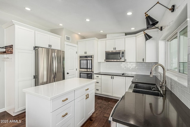 18820 N 33rd Ave, Phoenix, AZ 85027 - kitchen featuring stainless steel appliances, a kitchen island, dark wood-type flooring, dark countertops, and tasteful backsplash